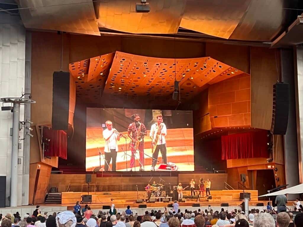 Seun Kuti and his band performing onstage at Jay Pritzker Pavilion during an outdoor Chicago concert