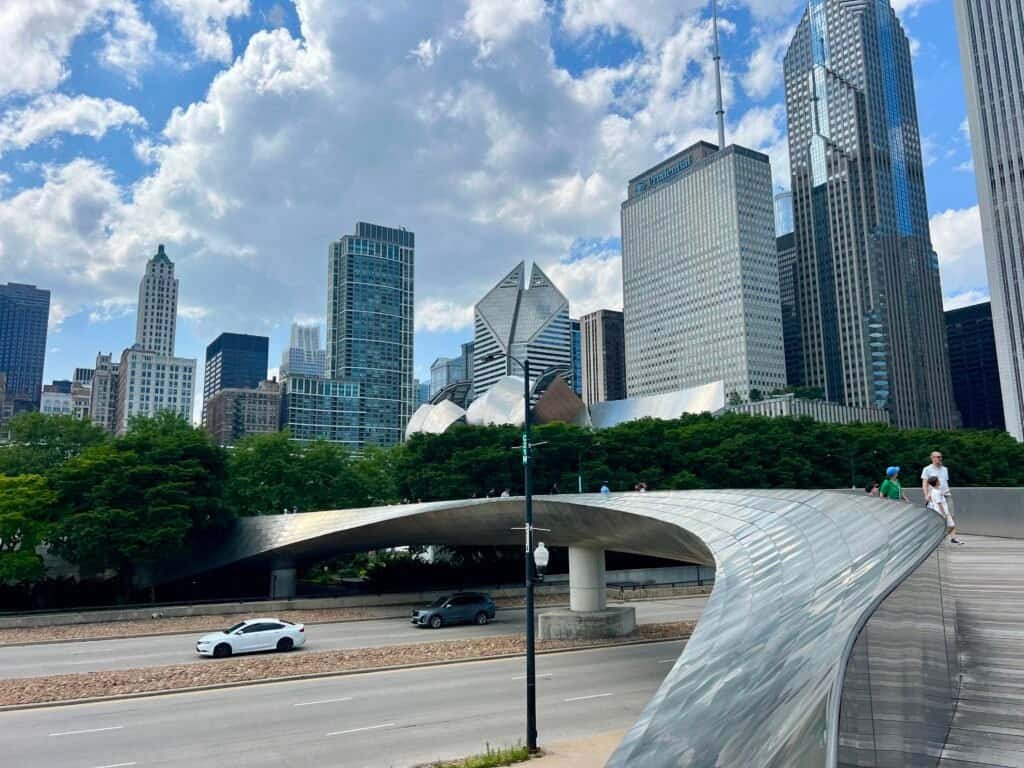 Curving BP Pedestrian Bridge spanning Columbus Drive with Chicago skyline and Jay Pritzker Pavilion