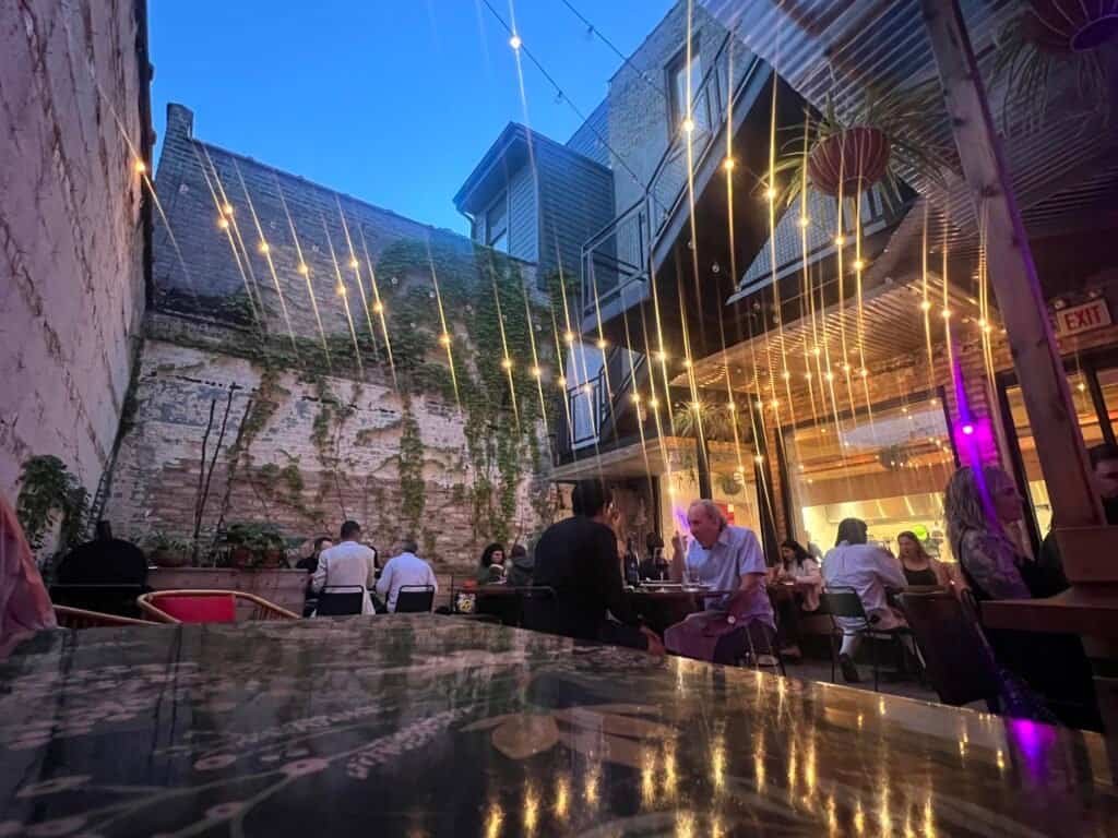 Evening patio dining at Superkhana International with string lights and guests enjoying dinner.