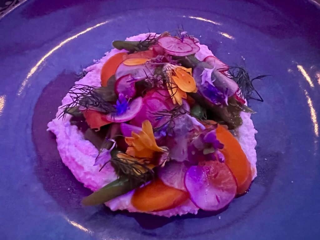 Whipped paneer topped with pickled vegetables, herbs, and edible flowers at Superkhana International