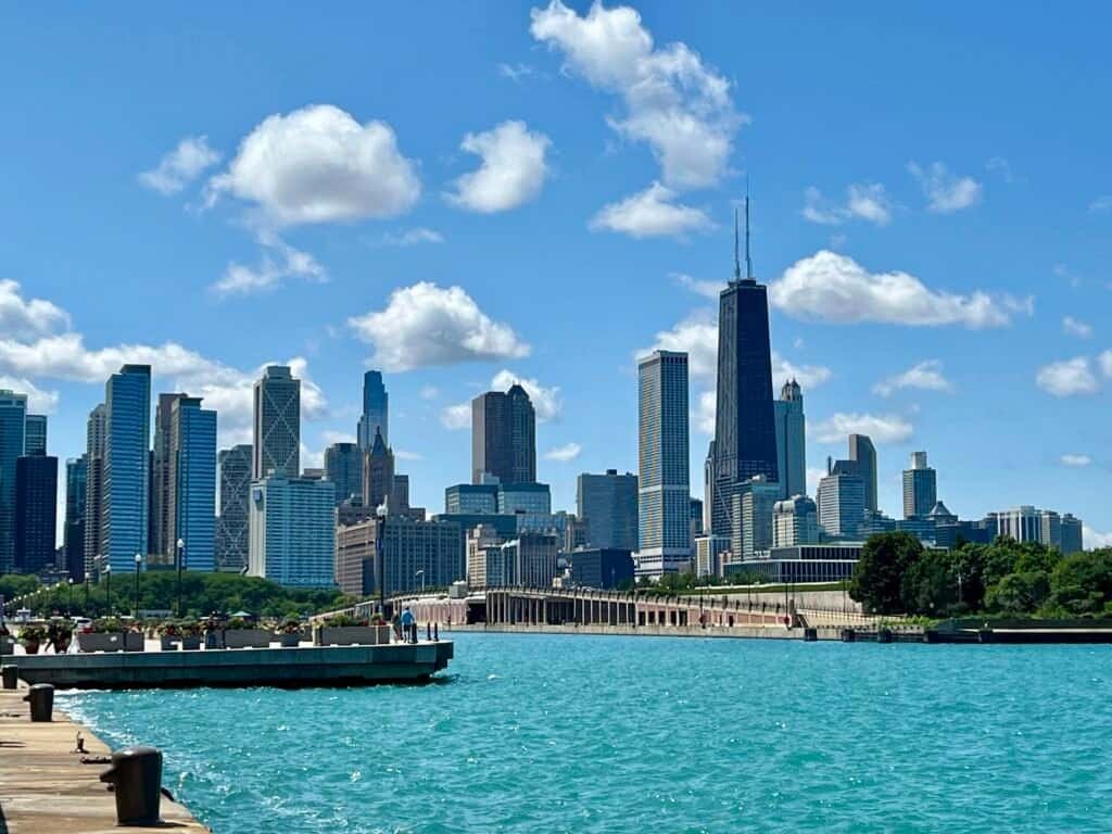 Chicago skyline viewed from the lakefront on a sunny day, with turquoise Lake Michigan in the foreground