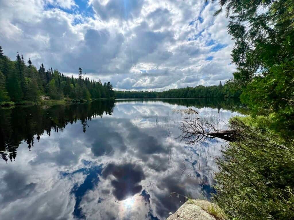 Whale Lake reflecting clouds and surrounding forest along the Eagle Mountain trail in Minnesota’s Boundary Waters Canoe Area Wilderness.