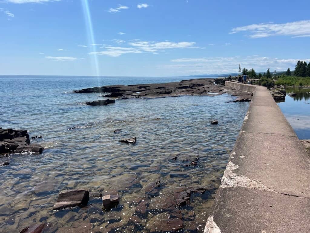 Clear, shallow water along a concrete pier with Lake Superior stretching to the horizon