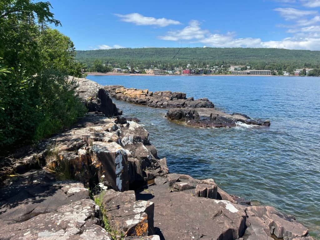 Rocky shoreline at Artist Point looking back toward the town of Grand Marais along Lake Superior.