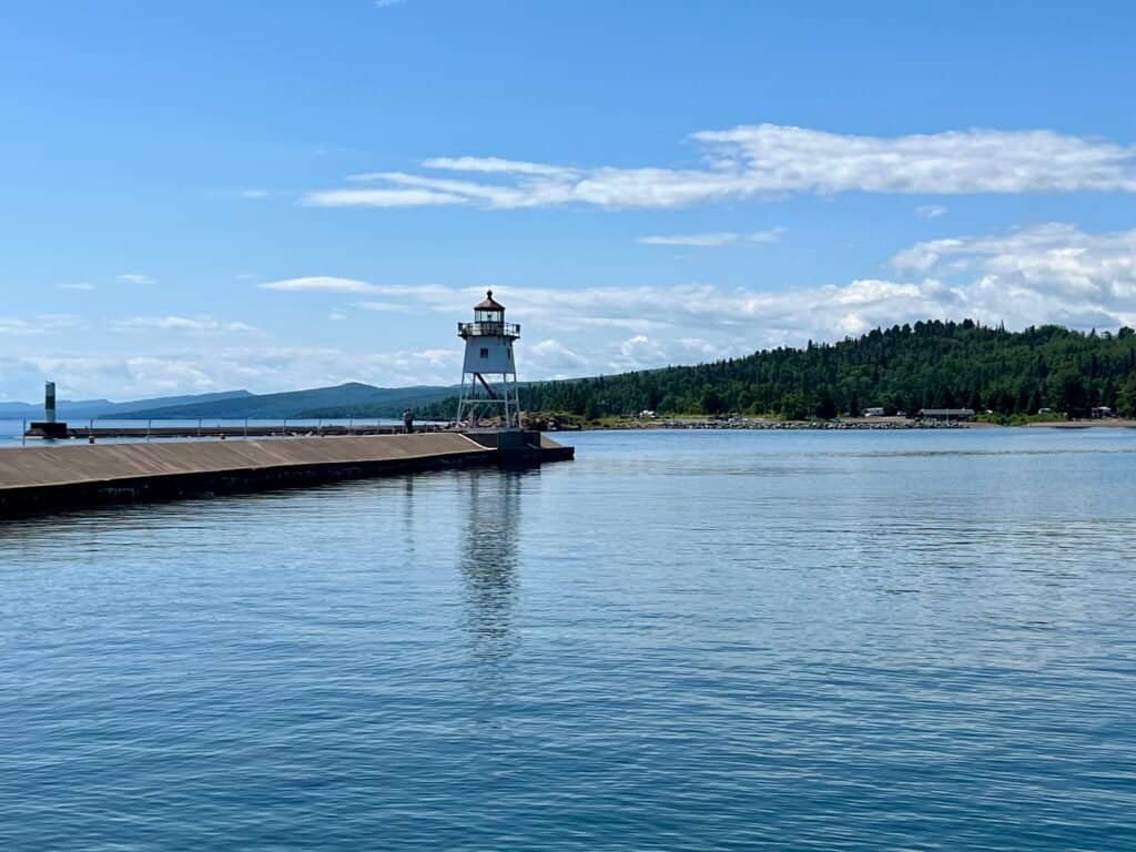 Grand Marais Lighthouse at the end of the breakwater on Lake Superior under blue skies