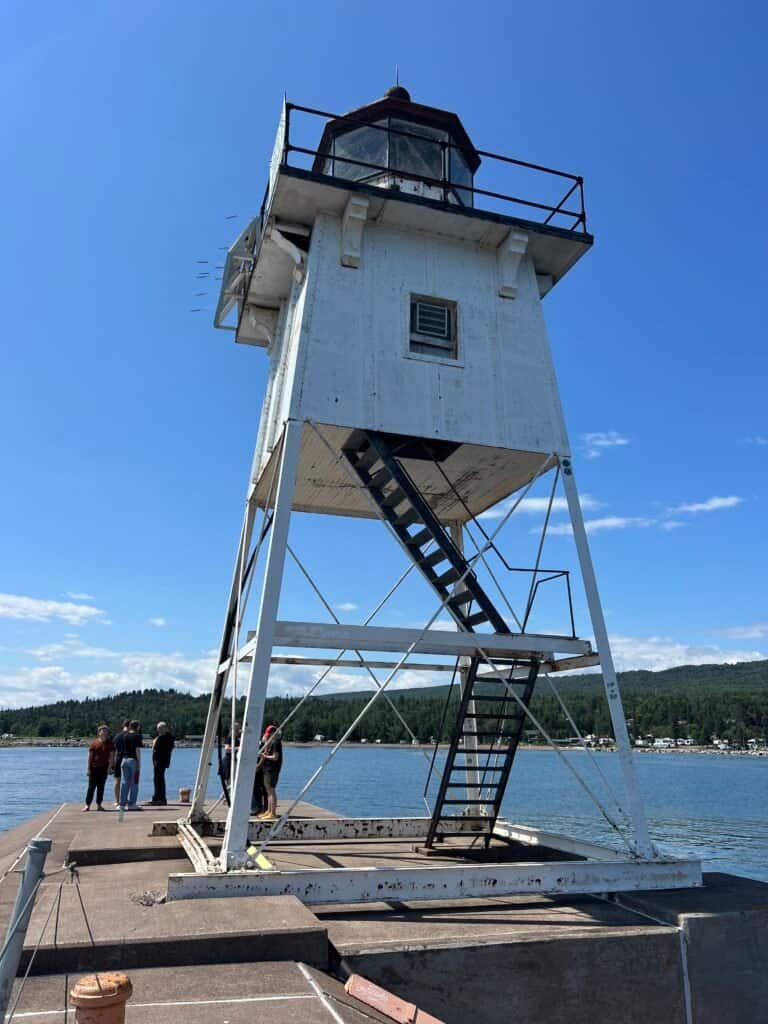 Close-up view of the Grand Marais Lighthouse with stairs and visitors on the pier