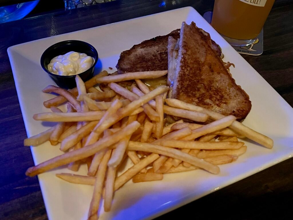 Loaded grilled cheese sandwich with French fries and a side of mayo at Déco restaurant.