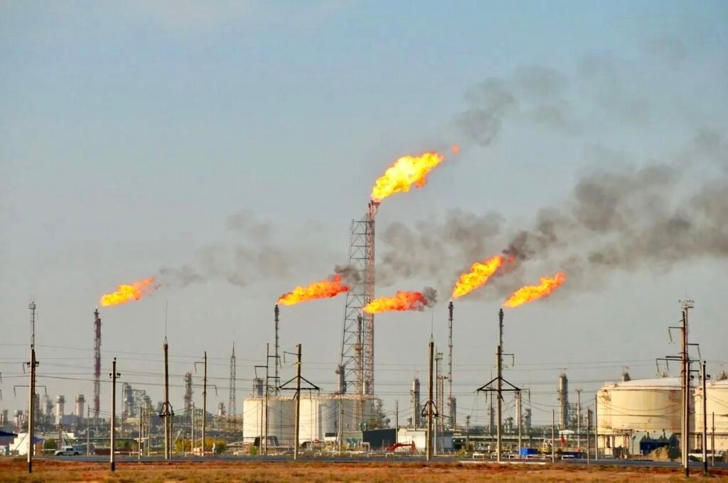 Oil refinery with gas flares burning above storage tanks near El Dorado, Arkansas