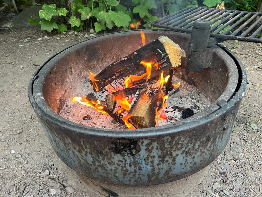 Campfire burning in a metal fire ring at Baptism River Campground in Tettegouche State Park.