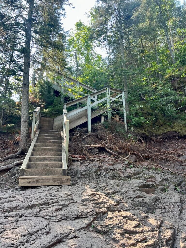 Wooden staircase climbing rocky shoreline near Two Step Falls in Tettegouche State Park.: