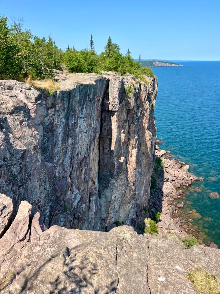 Dramatic cliffs of Palisade Head overlooking Lake Superior with Shovel Point visible in the distance.