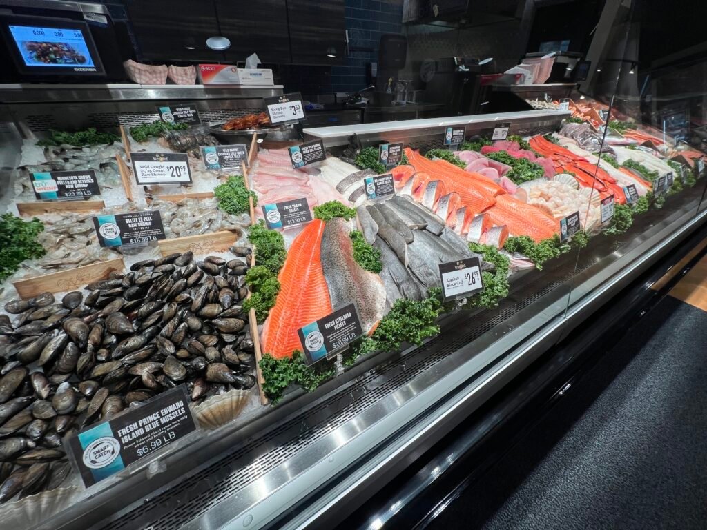 Seafood display case at Kowalski’s Market featuring fresh salmon, shellfish, and mussels.